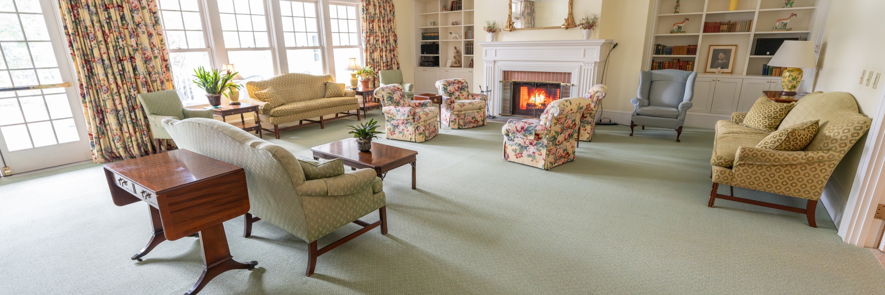 A cozy living room with a lit fireplace at Clara Welch Thanksgiving Home, 48 Grove Street, Cooperstown New York